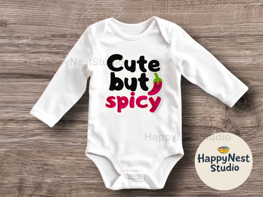 White baby onesie with bold text “Cute but Spicy” featuring a smiling red chili pepper design, perfect for sassy baby girl or baby boy outfits. Custom handmade heat-pressed design from HappyNest Studio, cute and spicy baby onesie for 0-3 to 18 months.