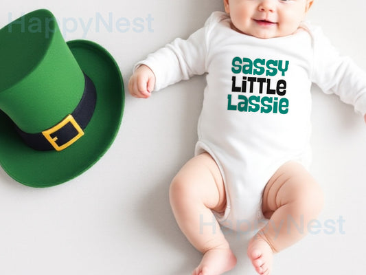 White long-sleeve baby onesie featuring a unique, shop-owner–designed sublimated printable-vinyl graphic that reads ‘Sassy Little Lassie’ in bold black and Irish green lettering. This handmade Saint Patrick’s Day baby bodysuit is perfect for Irish-themed celebrations, newborn baby gifts, or a cute everyday outfit for infant girls. Ideal for shoppers searching for shamrock-inspired newborn clothing, green baby onesies, sublimation baby outfits, and funny, cute Irish baby gift ideas.