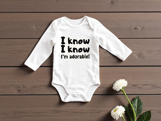 White long-sleeve baby onesie featuring a unique, sublimated printable-vinyl graphic that reads “I know I know I am adorable” in bold black lettering. the design highlights the crisp, high-quality sublimation print and modern typography. Ideal for parents and gift-givers searching for funny baby onesies, newborn baby clothing, gender-neutral infant outfits, cute baby shower gifts, custom sublimation onesies, or adorable newborn gift ideas for gifting to expecting parents.