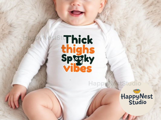Halloween baby onesie – white long‑sleeve cotton bodysuit with envelope shoulders and bottom snap closures, featuring the playful orange and black “Thick thighs spooky vibes” print with a spooky cat graphic, perfect spooky vibes baby bodysuit for fall photoshoots and Halloween outfit.