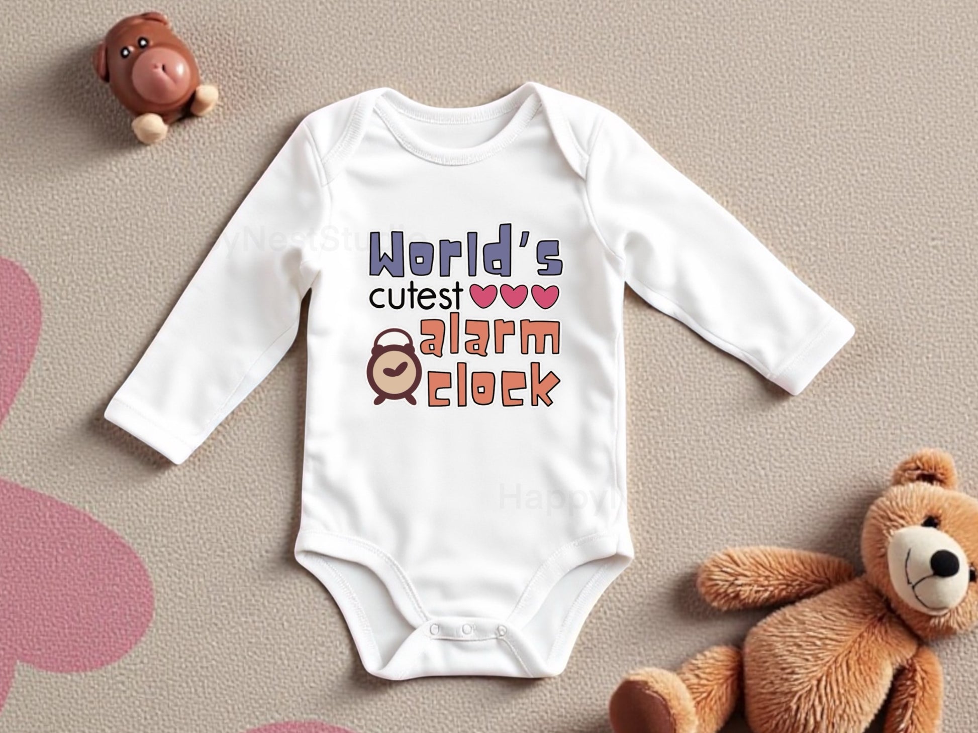 Adorable white baby onesie with original design that says “World’s Cutest Alarm Clock” in colorful, playful fonts, accented with three pink hearts and a cute cartoon alarm clock illustration. Perfect for parents shopping funny baby clothes, sleep-themed infant outfits, or unique newborn baby shower gifts. The design is sublimated onto the fabric using printable vinyl for a vibrant and lasting finish. Created in-house by the shop owner. 