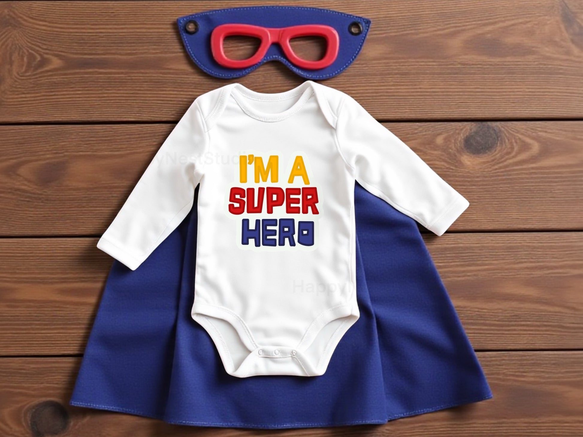 White long-sleeve baby onesie featuring a unique, shop-owner–designed sublimated printable-vinyl graphic that reads ‘I’m a Super Hero’ in bold yellow, red, and blue lettering. Made from soft, comfortable cotton with secure snap closures, this handmade superhero baby bodysuit makes a wonderful newborn gift, baby shower present, or cute everyday outfit. Ideal for parents searching for funny baby onesies, superhero baby outfits, sublimation onesies, newborn gift ideas.