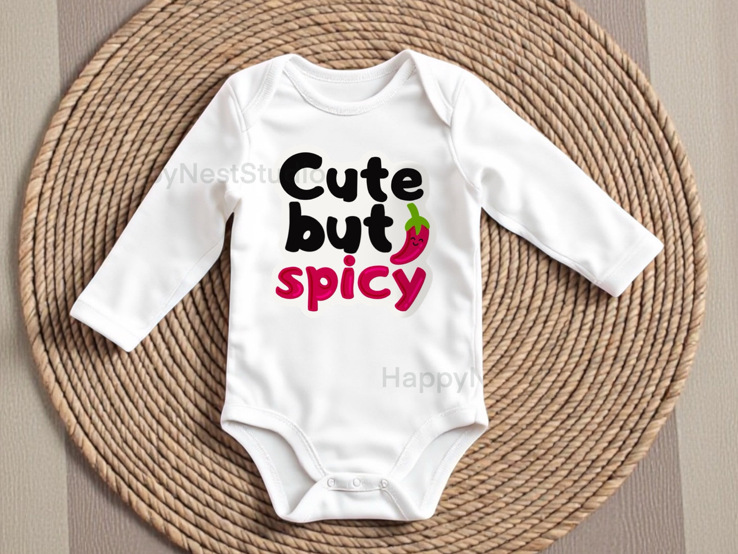 White baby onesie with bold text “Cute but Spicy” featuring a smiling red chili pepper design, perfect for sassy baby girl or baby boy outfits. Custom handmade heat-pressed design from HappyNest Studio, cute and spicy baby onesie for 0-3 to 18 months.